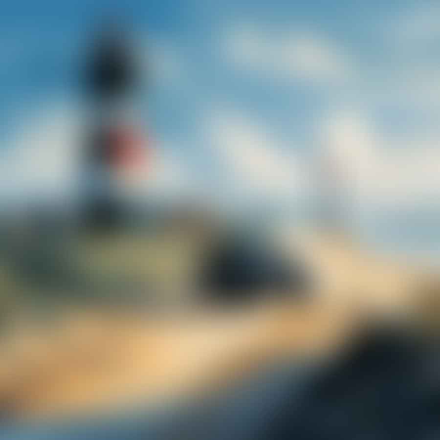 Cape Hatteras Lighthouse with vehicles driving on the beach